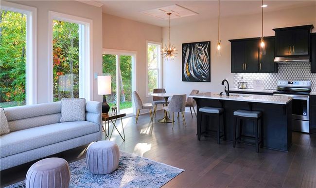 Kitchen with a center island with sink, electric stove, open floor plan, light countertops, and pendant lighting | Image 13