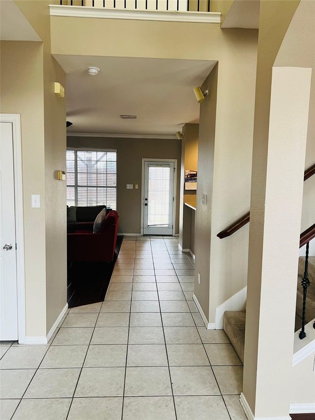 Entryway featuring crown molding and light tile patterned floors | Image 4
