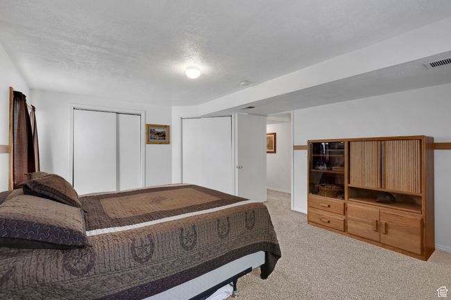 Bedroom featuring light carpet, baseboards, and a textured ceiling | Image 29