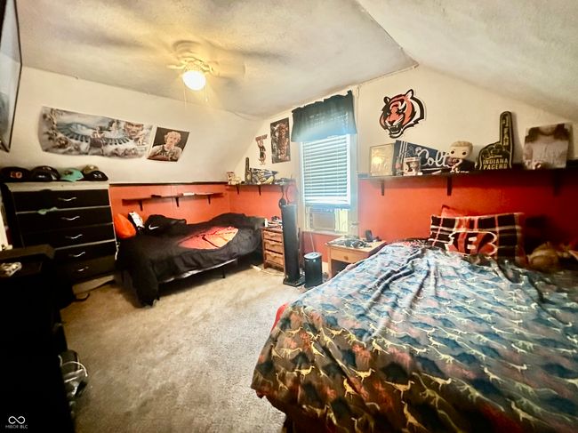 carpeted bedroom with vaulted ceiling, a ceiling fan, a textured ceiling, and cooling unit | Image 28
