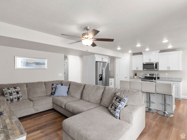 Living area featuring recessed lighting, arched walkways, ceiling fan, and light wood-type flooring | Image 6