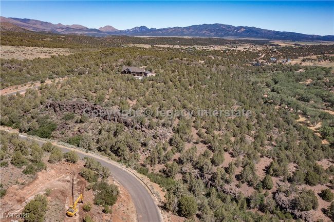 Aerial overview of property's location featuring a mountainous background and a heavily wooded area | Image 16