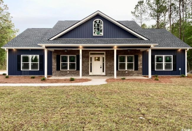 Craftsman house featuring a shingled roof, a front yard, covered porch, and board and batten siding | Image 4