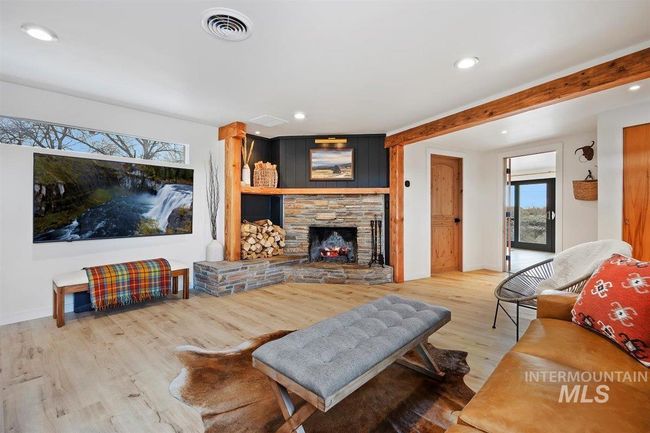 Living area featuring wood finished floors, recessed lighting, a stone fireplace, and beamed ceiling | Image 30