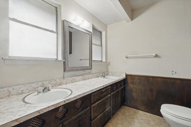 Bathroom with double vanity, toilet, a textured ceiling, and tile patterned flooring | Image 26