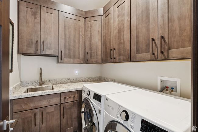 Washroom featuring washing machine and dryer and cabinet space | Image 52