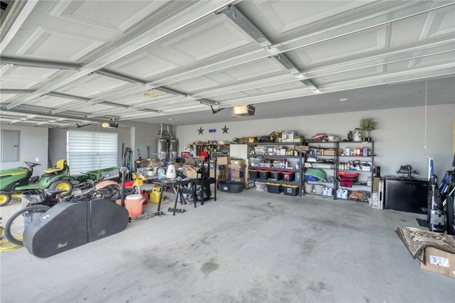 Garage featuring a garage door opener and a workshop area | Image 41