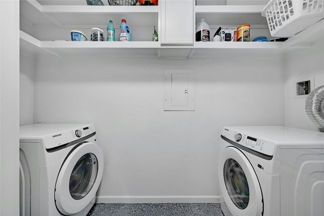 The laundry room contains updated epoxy flooring, W/D connections, and overhead shelf space for your laundry needs. | Image 27