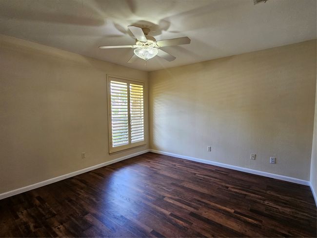 Spare room with ceiling fan and dark wood-style floors | Image 7