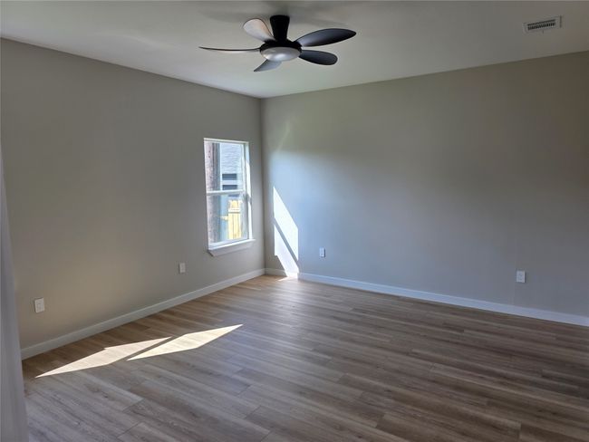 Primary bedroom featuring ceiling fan, wood finished floors, and baseboards | Image 5