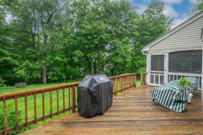 Extra large deck off screened-in porch with stairs leading to fabulously landscaped backyard. | Image 25