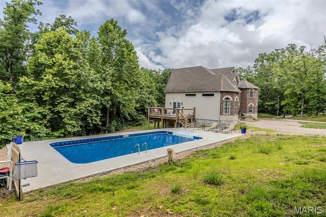 Outdoor pool with a deck, a patio, and stairway | Image 57
