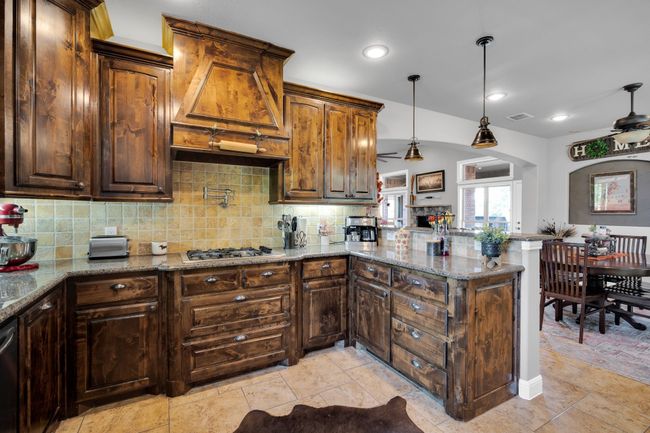 Kitchen featuring ceiling fan, stone countertops, and backsplash | Image 10