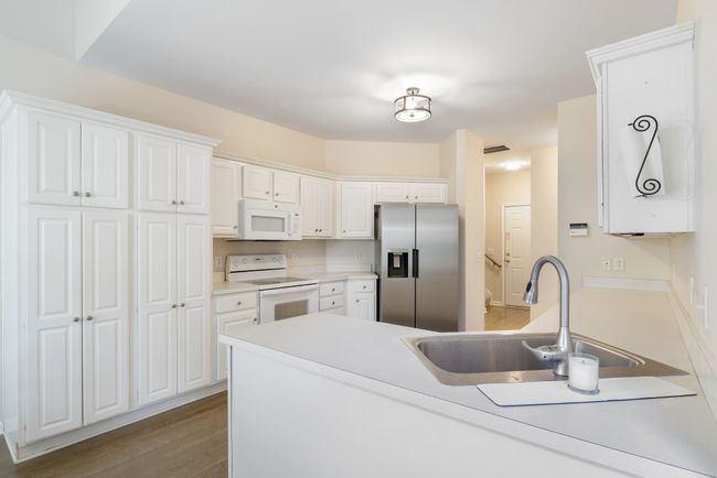 Kitchen has numerous cabinets for storage and ample worktop space for meal prep | Image 12