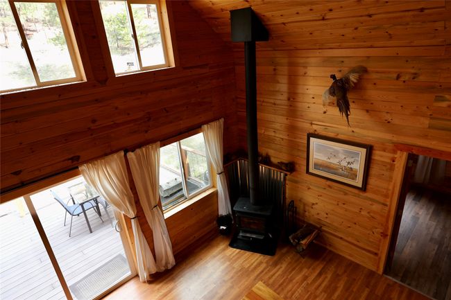 Unfurnished room with a wood stove, wood walls, and light wood-style floors | Image 40