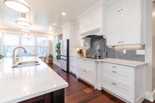 Kitchen featuring freestanding refrigerator, black electric stovetop, dark wood finished floors, white cabinetry, and tasteful backsplash | Image 10