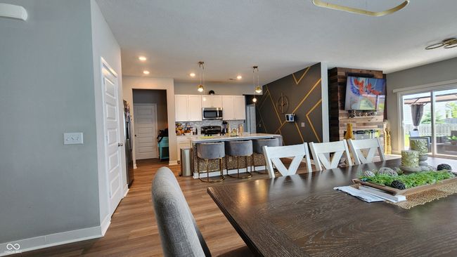 dining room with wood finished floors, a large fireplace, and recessed lighting | Image 4