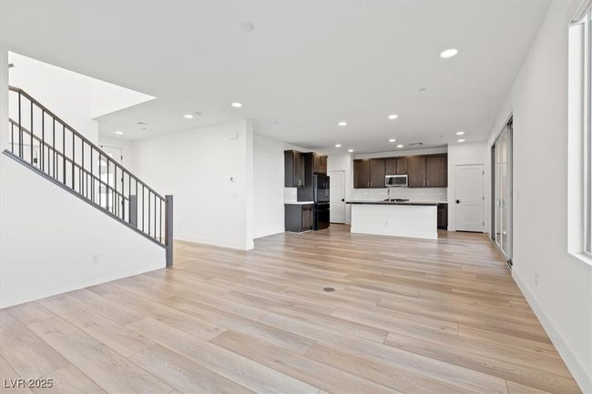 Unfurnished living room featuring baseboards, recessed lighting, light wood-type flooring, and stairs | Image 24