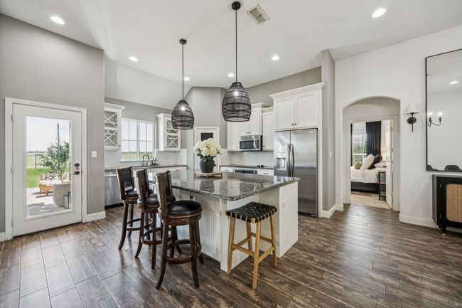 Kitchen with appliances with stainless steel finishes, a kitchen island, white cabinetry, healthy amount of natural light, and recessed lighting | Image 5
