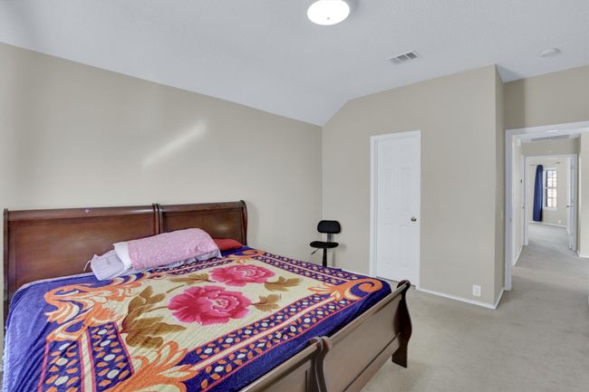 Bedroom with lofted ceiling, baseboards, visible vents, and light colored carpet | Image 30