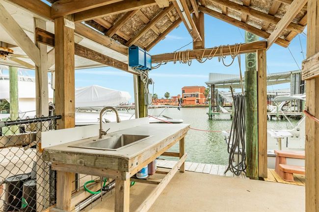 This photo showcases the fishing cleaning station with electricity and water ideal for boating enthusiasts. The view includes boats and a serene waterway, perfect for enjoying a coastal lifestyle. | Image 39