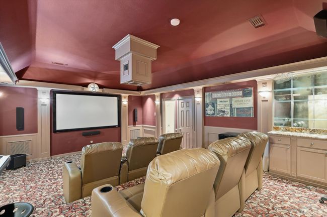 Home theater featuring a decorative wall, a wainscoted wall, and a tray ceiling | Image 21