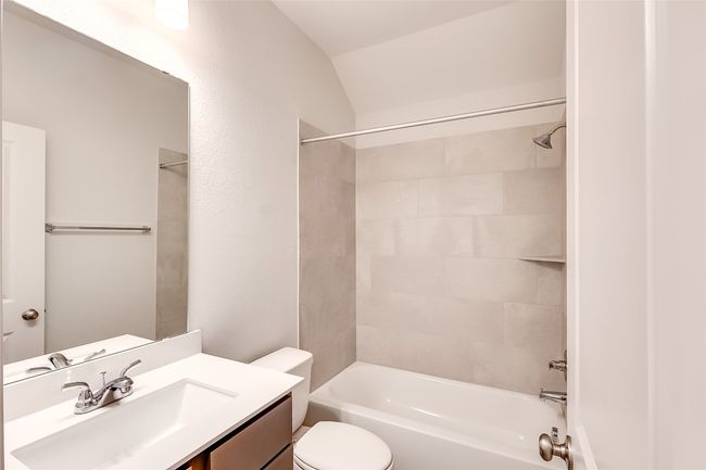 Bathroom with vanity, toilet, tub / shower combination, and lofted ceiling | Image 22