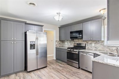 updated kitchen with granite counters, new cabinets, stainless appliances including refrigerator | Image 2