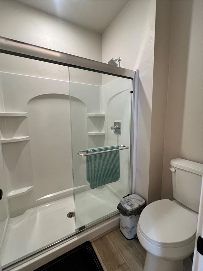 On-suite bathroom with a shower stall, lvp flooring, and toilet | Image 14