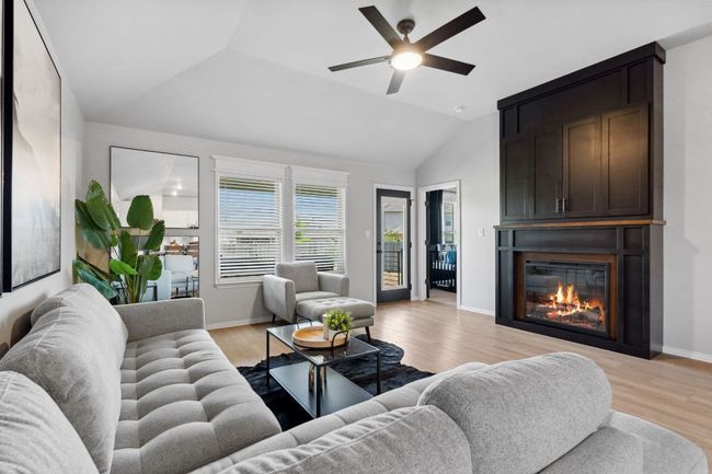 The living room is anchored by a magnificent fireplace display. | Image 16