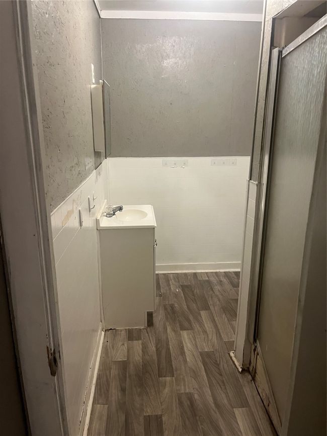 Full bathroom with a shower stall, wainscoting, wood finished floors, and vanity | Image 17