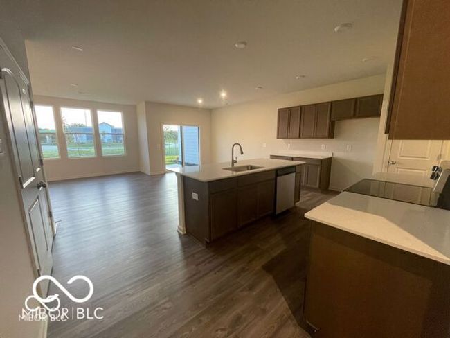 kitchen featuring stainless steel dishwasher, stove, dark wood-style floors, and a sink | Image 5