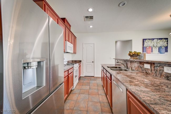 Kitchen featuring stainless steel appliances, stone countertops, recessed lighting, and tile patterned floors | Image 13