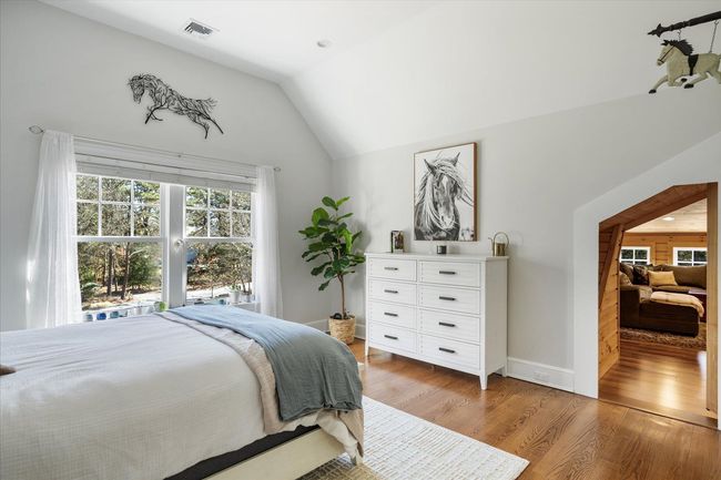 Bedroom with baseboards, light wood-style flooring, visible vents, and vaulted ceiling | Image 25