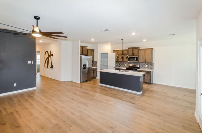 Kitchen featuring appliances with stainless steel finishes, a sink, a ceiling fan, tasteful backsplash, and recessed lighting | Image 7