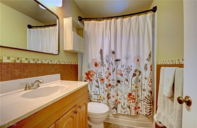Full bathroom featuring vanity, tile walls, and a wainscoted wall | Image 26