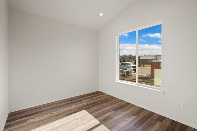 Unfurnished room with vaulted ceiling, recessed lighting, wood finished floors, and baseboards | Image 18