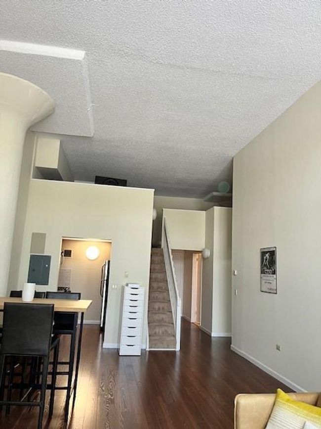 Living room with dark wood-type flooring and a textured ceiling | Image 6