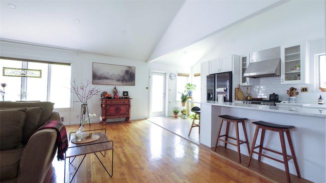 Living area featuring light wood-type flooring, baseboards, and high vaulted ceiling | Image 6