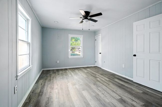 Unfurnished bedroom with wood finished floors, crown molding, and a ceiling fan | Image 13