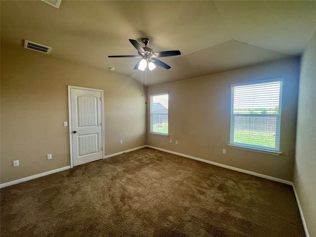 Carpeted primary bedroom featuring ceiling fan and baseboards | Image 13