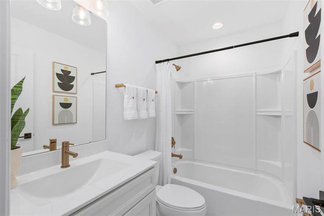 Bathroom featuring vanity, toilet, and shower / bath combo with shower curtain | Image 6