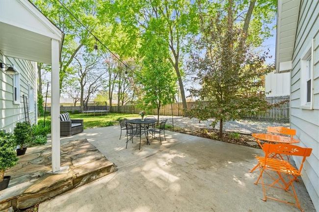 View of patio featuring outdoor dining area, a trampoline, and a fenced backyard | Image 24