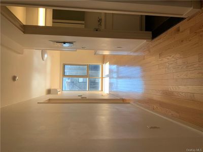 Hallway with an AC wall unit, and light wood flooring | Image 1