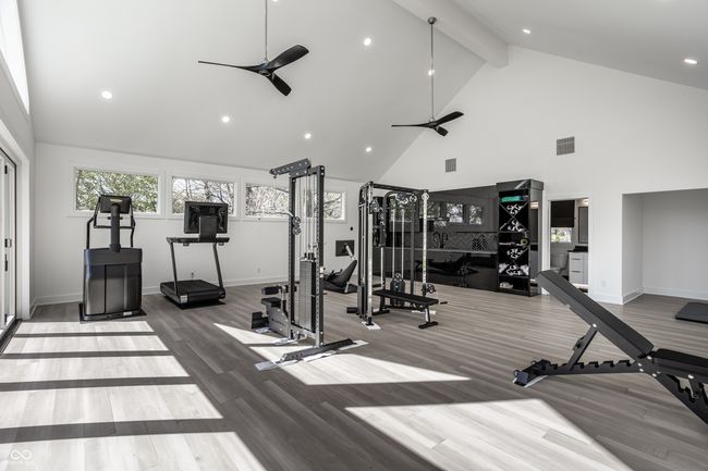 gym with ceiling fan, wood finished floors, high vaulted ceiling, and visible vents | Image 58