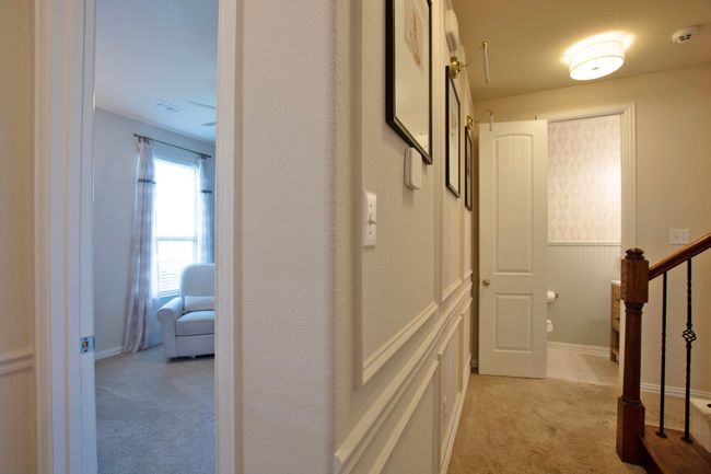Hallway with light colored carpet, wainscoting, visible vents, and stairway | Image 29