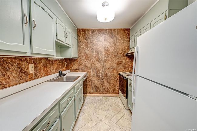 Kitchen with white appliances, green cabinets, and sink | Image 4