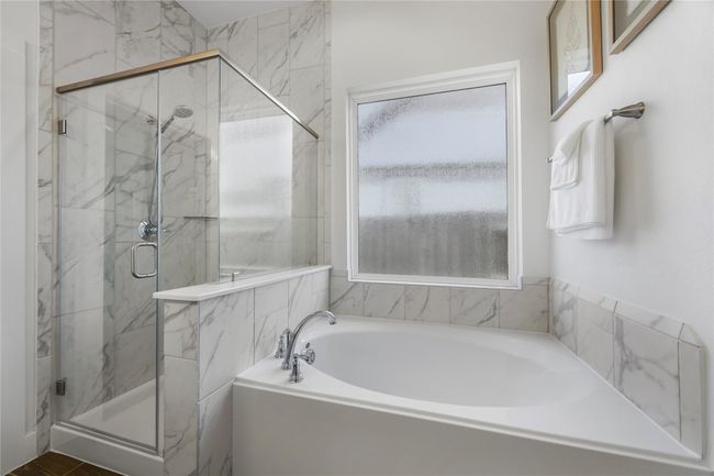 Enjoy a long soak in the relaxing garden tub or refresh under the separate glass-enclosed shower, this private bath feels like your own personal spa. | Image 21