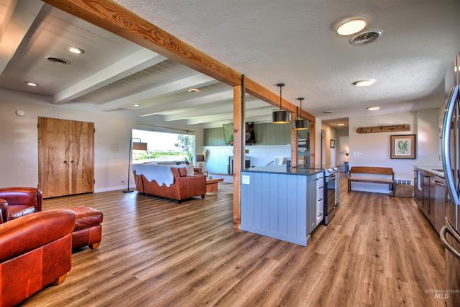 Kitchen with open floor plan, light wood-type flooring, beam ceiling, a textured ceiling, and recessed lighting | Image 10