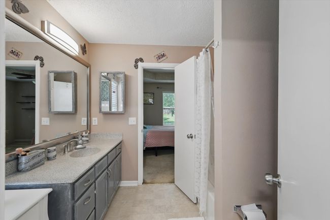 Full bathroom with baseboards, vanity, a textured ceiling, and a shower with shower curtain | Image 25